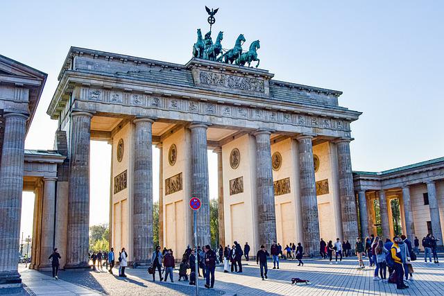 Bild på Brandenburger Tor i Berlin, med ett hav av turister i förgrunden.